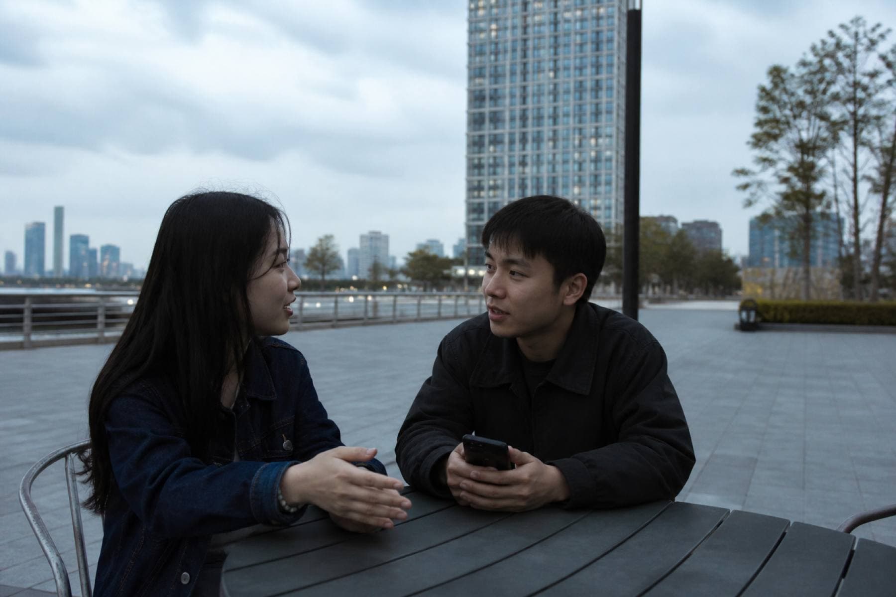 Two people talking at an outdoor table