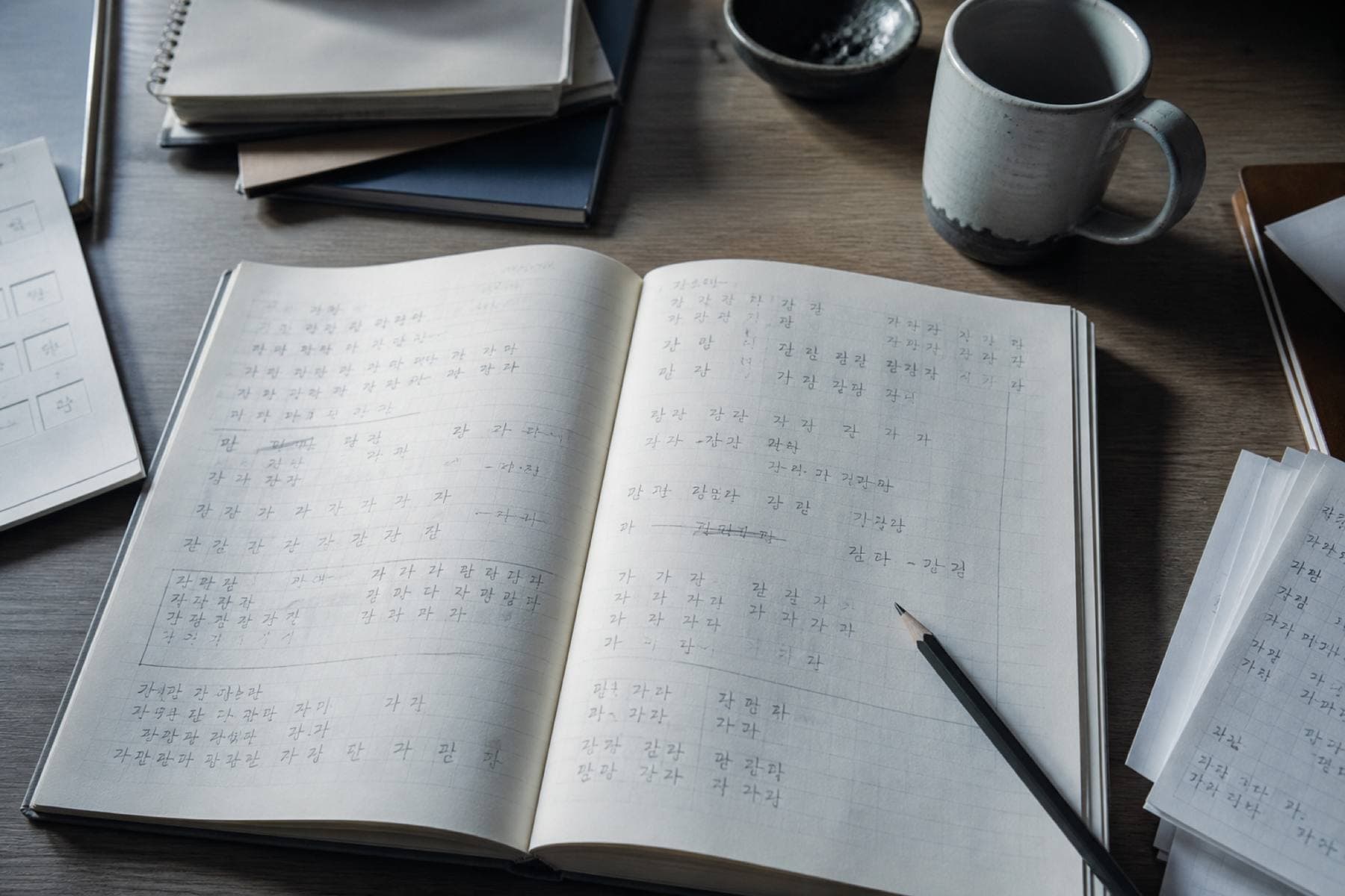 An open notebook with handwritten Korean practice